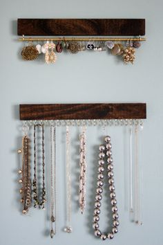 several necklaces are hanging on the wall with wooden pegs and beads attached to them