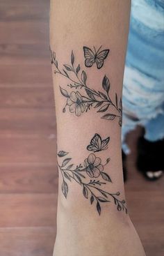 a woman's arm with flowers and butterflies on it