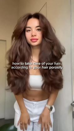 a woman with long brown hair standing in front of a mirror and holding her hands on her hips