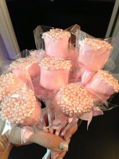 a bouquet of pink and white candy wrapped in cellophane with pearls on them