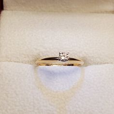 an engagement ring with a single diamond sits in a box