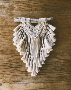 a white piece of cloth hanging on top of a wooden table covered in tassels