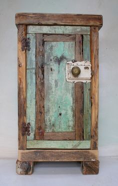 an old wooden cabinet with peeling paint on the door and handle is sitting against a white wall