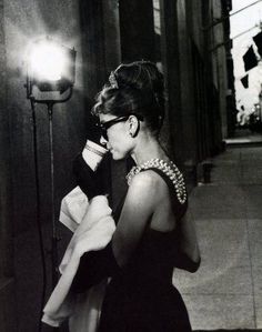 a black and white photo of a woman talking on a cell phone while walking down the street