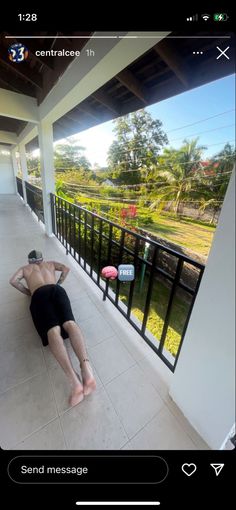 a man laying on the ground in front of a balcony