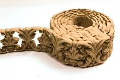 an intricately carved piece of wood on a white surface