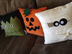 three halloween pillows sitting on top of a couch