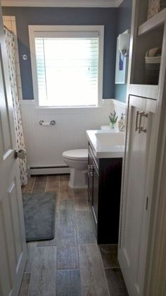 a bathroom with a toilet, sink and window