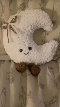 a crocheted white teddy bear laying on top of a bed