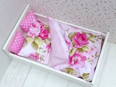 a white box with pink flowers and polka dots on the lid is filled with pillows