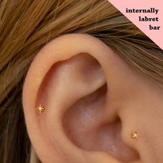 a close up of a person's ear with three small stars on the side