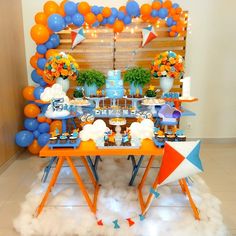 an orange and blue dessert table with balloons