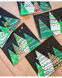 paper christmas trees are arranged on top of each other, with black and green background