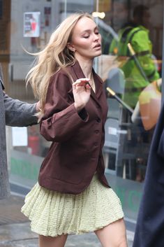 a woman is walking down the street with her hand in her pocket