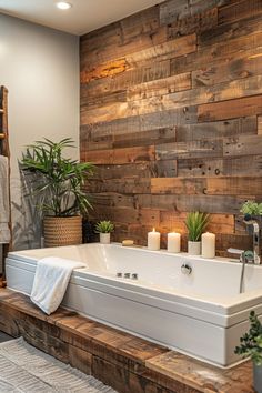 a bath tub sitting next to a wooden wall with candles on the side and potted plants