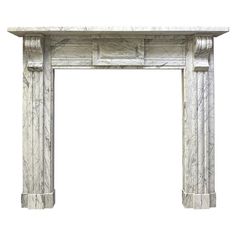 a white marble fireplace mantel with columns