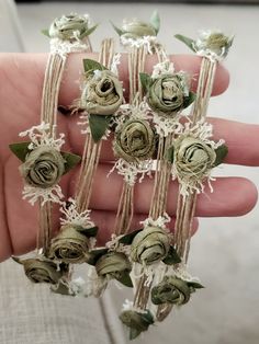 a person is holding several small flowers in their hand and it looks like they have been made out of fabric