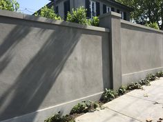 a concrete fence is shown in front of a house