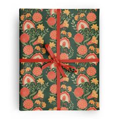 a gift box wrapped in green and orange floral paper with a red ribbon tied around it