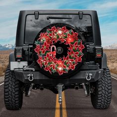 a decorated christmas wreath on the back of a black jeep parked in a parking lot