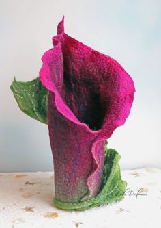 a pink and green vase sitting on top of a table