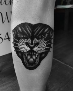 a black and white photo of a tiger's head on the leg with an inscription