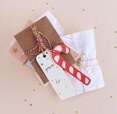 an ornament on top of some wrapping paper with a tag attached to it