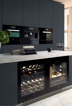 a kitchen with black cabinets and marble counter tops, an oven is open to show baked goods