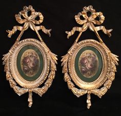 two ornate gold framed paintings on black background