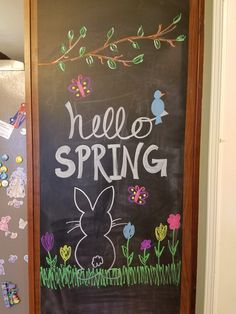 a chalkboard with the words hello spring written on it in front of a door