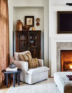 a living room filled with furniture and a fire place in the middle of the room