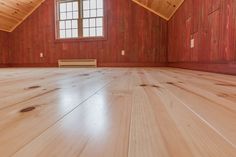 an empty room with wood floors and red walls