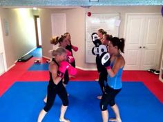 a group of young women practicing boxing in a room with blue and red flooring