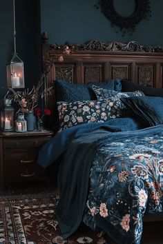 a bed with blue comforter and pillows in a dark room next to a dresser