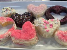 a white plate topped with lots of different types of doughnuts on top of each other