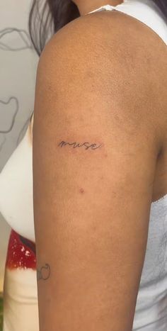 a woman with a small tattoo on her arm that reads, misse in cursive writing