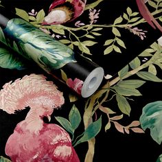 a black floral wallpaper with pink flowers and green leaves on the background is a roll of toilet paper