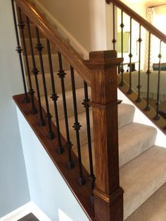 the stairs are made of wood and have wrought iron balconies on them, along with carpeted flooring