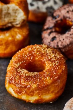 there are many different types of donuts on the table together, including one with sesame sprinkles