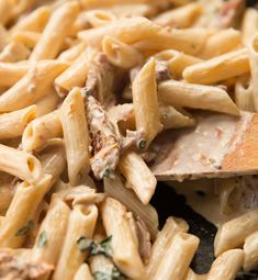 pasta with meat and spinach is being stirred by a wooden spoon