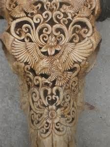 an animal's head is carved with intricate designs on it, and has horns