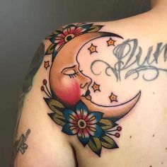 the back of a woman's shoulder with a moon and stars tattoo on it