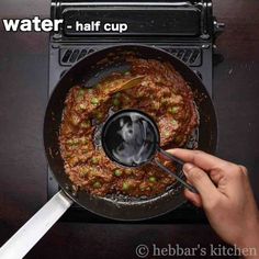 someone is stirring some food in a skillet on the stove with a spatula