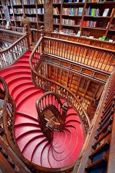 a spiral staircase in a library with bookshelves