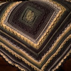 there is a crocheted blanket on top of a couch with a brown chair