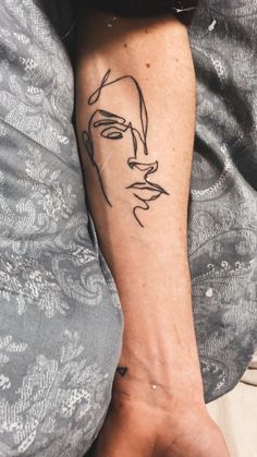 a woman's arm with a tattoo on it that has a man's face