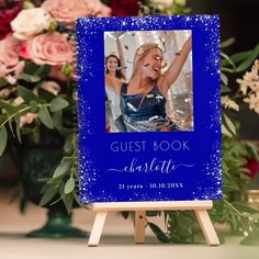 a blue sign with a photo of a woman on it and flowers in the background