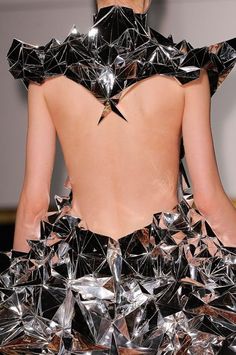 the back of a woman's dress made out of silver foil