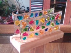 a colorful glass sculpture sitting on top of a wooden table