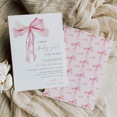 two cards with pink bows on them sitting next to each other, one is folded and the other has an envelope